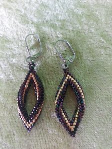 Ohrringe in Rautenform, gedreht, dunkellila mit einem Goldstreifen in der Mitte, aus Glasperlen, Verschluß aus Edelstahl