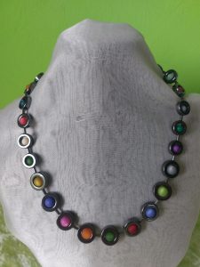 Kette aus antrazitfarbenen Hämatit Donuts, gefüllt mit Polaris Kugeln im Farbmix, dazwischen kleine Hämatit Stäbchen in antrazitfarben