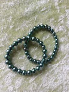 zwei glänzende Armbänder aus grünen Glaskugeln, dehnbar (Gummi)