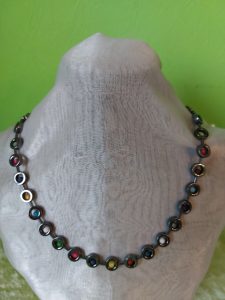 Kette aus antrazitfarbenen Hämatit Donuts, gefüllt mit Polaris Kugeln im Farbmix, dazwischen kleine Hämatit Stäbchen in antrazitfarben